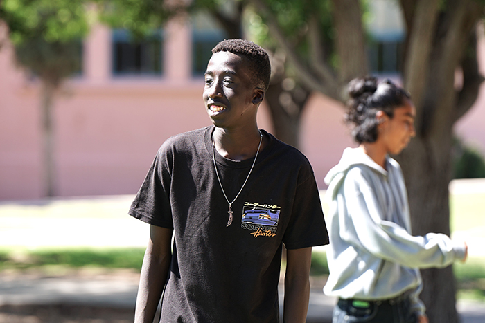 A teen boy smiles outside