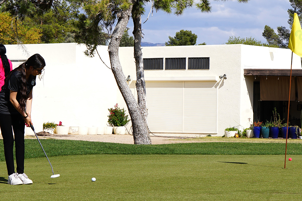 A girl lines up her shot on the golf course