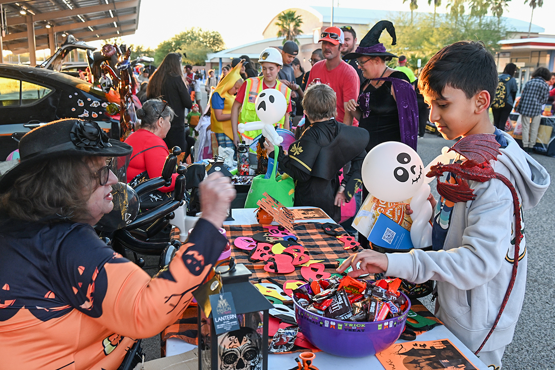 A boy picks out candy from a bowl at one of the tables