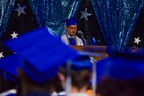 A student speaks to his class during graduation
