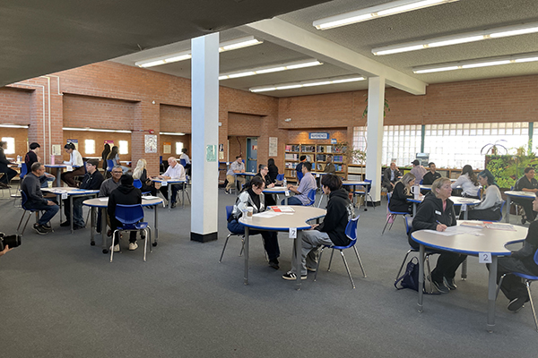 A library filled with tables where students are conducting mock interviews