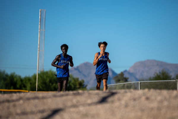 Two teen boys in blue Catalina singlets run the cross country course