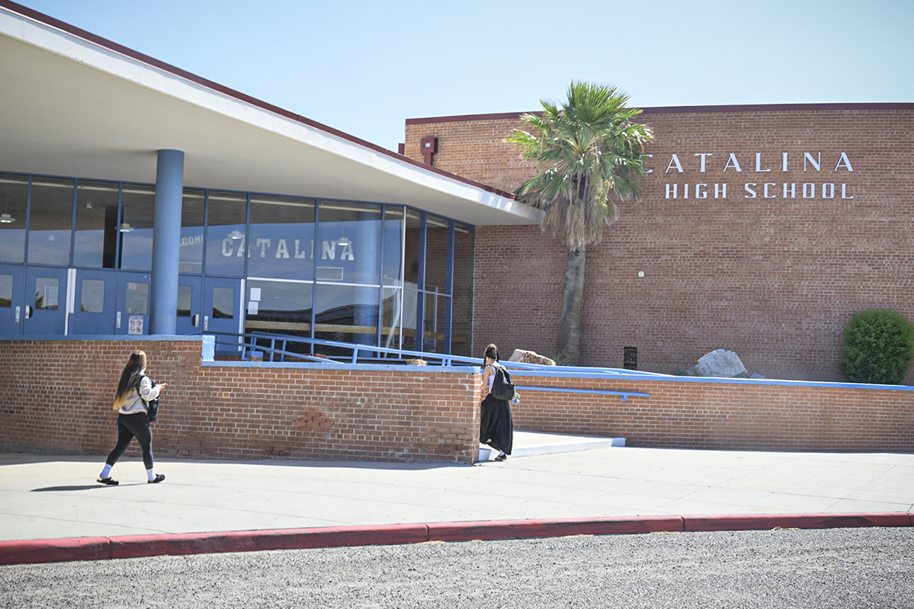 A teen girl walks outside the school building